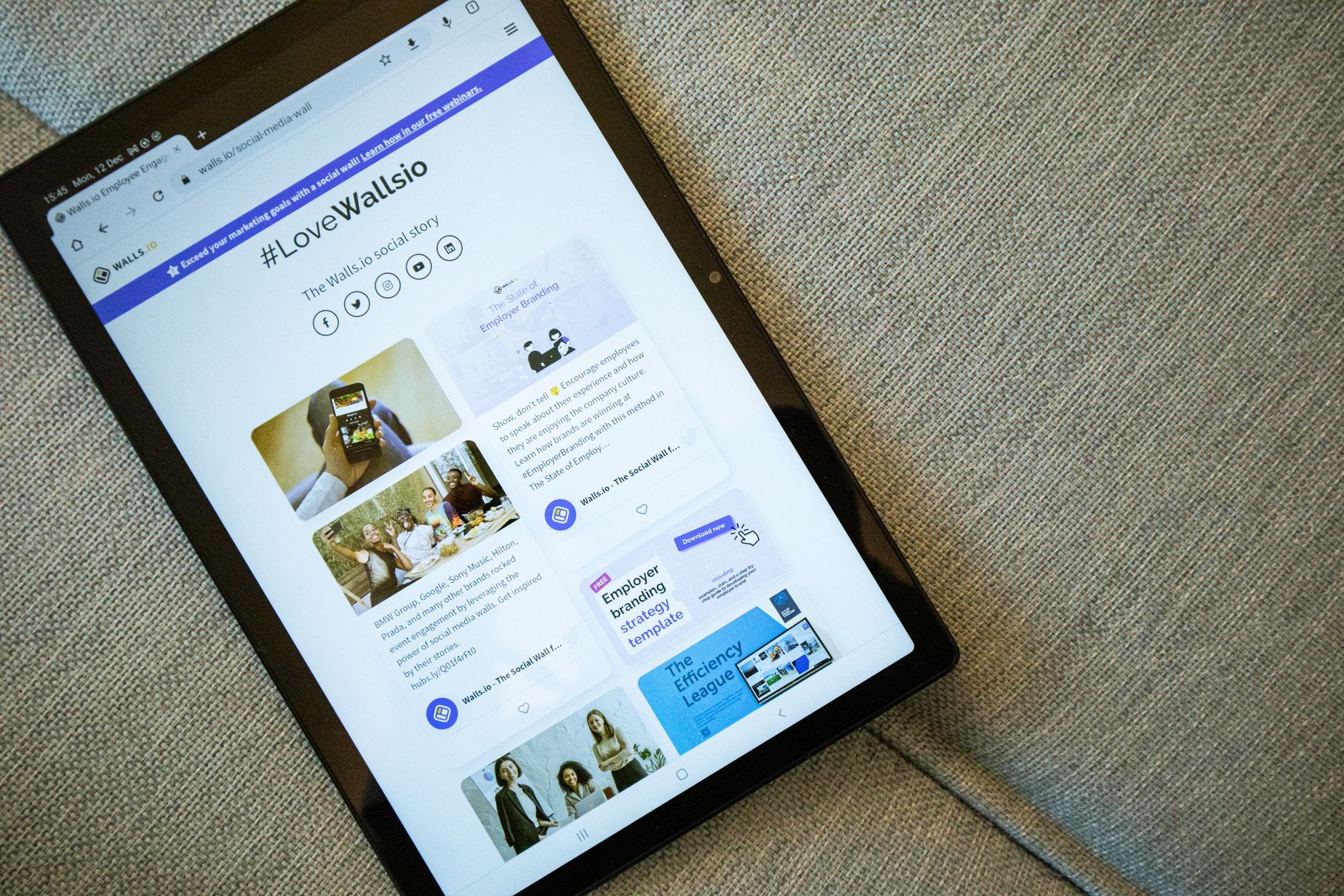 Tablette posée sur un canapé affichant un fil d'actualités et de contenus