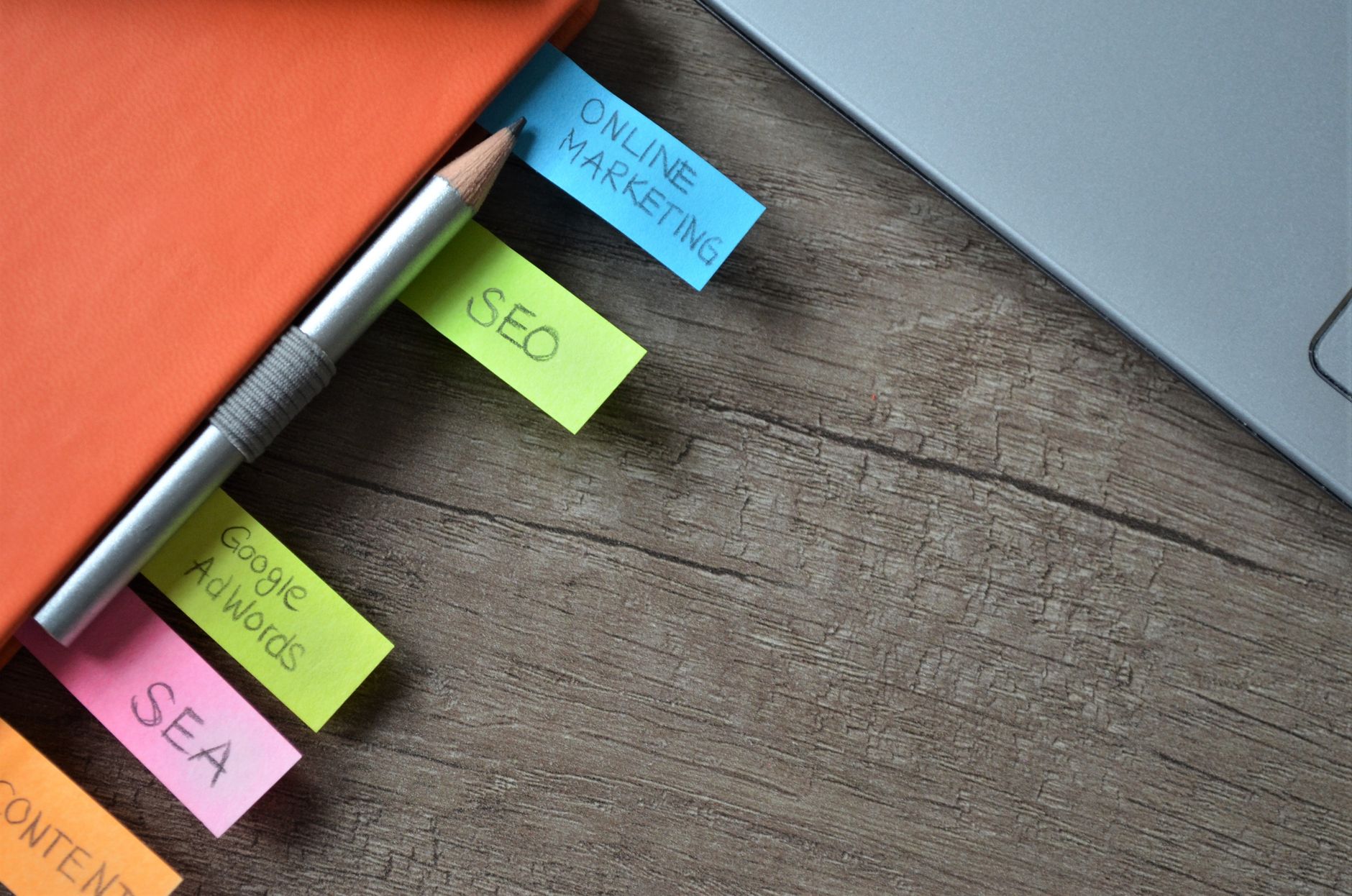 Post-it annotés SEA, Google AdWords, SEO et online marketing posés près d'un ordinateur portable